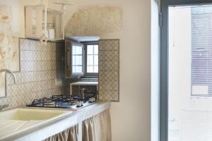 a kitchen with a stove and a sink and a window at Casa Anmori in Ostuni