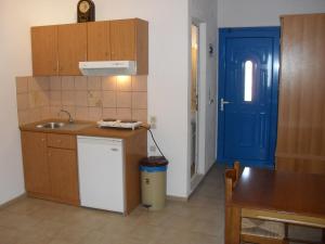 a kitchen with a sink and a blue door at Chris Apartments in Marathokampos