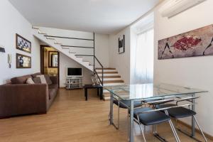 salon ze szklanym stołem i kanapą w obiekcie Alcalà Living Apartments w Katanii