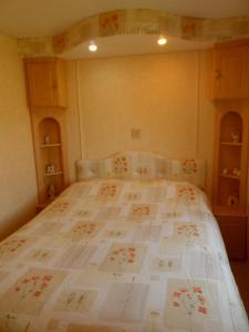 1 dormitorio con 1 cama grande y edredón blanco en Luxury Mobile Home near Perranporth situated on a quiet farm, en Truro