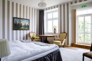 Schlafzimmer mit einem Bett, einem Tisch und Stühlen in der Unterkunft Hotell Breda Blick in Visby