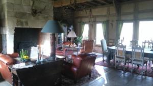 a living room with leather furniture and a fireplace at Ferme de la Haye in Montroty