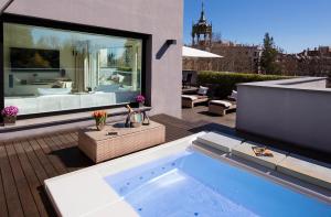 une baignoire jacuzzi sur une terrasse avec patio dans l'établissement ABaC Restaurant Hotel Barcelona GL Monumento, à Barcelone