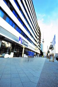 un grande edificio con una strada di fronte di H2 Hotel Berlin-Alexanderplatz a Berlino