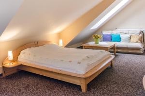 1 dormitorio con 1 cama y 1 sofá en el ático en Pensiunea Casa Tepes, en Brasov