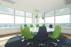 a conference room with a table and green chairs at Sky Hotel Apartments Tornet in Linköping