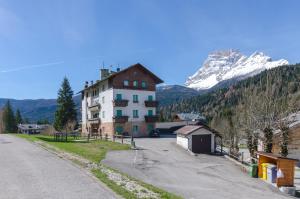 a building on the side of a road with a mountain at Appartamento Continental - 8 posti letto in San Vito di Cadore