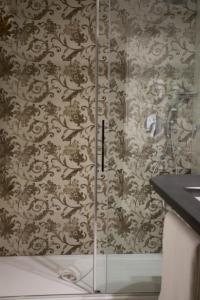 a shower in a bathroom with a wall covered in wallpaper at Grand Hotel Portovenere in Portovenere
