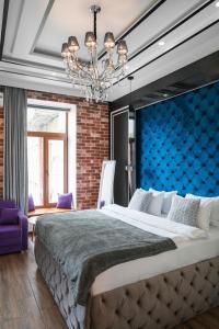 a bedroom with a large bed with a blue wall at Theatre Boutique Apart-Hotel in Kyiv