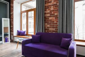 a purple couch in a room with a brick wall at Theatre Boutique Apart-Hotel in Kyiv