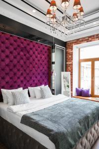 una camera con un grande letto con una parete viola di Theatre Boutique Apart-Hotel a Kiev