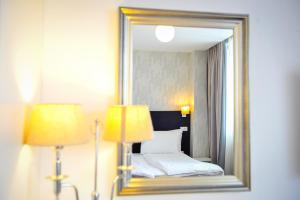 a hotel room with a bed and a mirror at Apart Hotel Vlad Tepes in Braşov