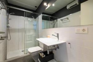 a bathroom with a toilet and a sink and a shower at Elvira Suites in Granada