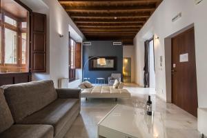 ein Wohnzimmer mit einem Sofa und einem Tisch in der Unterkunft Elvira Suites in Granada