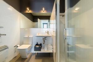 a bathroom with a toilet and a sink and a shower at Elvira Suites in Granada