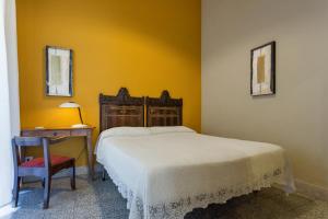 1 dormitorio con 1 cama, 1 mesa y 1 silla en Alcalà Living B&B, en Catania