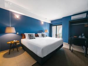 a bedroom with a large bed and a blue wall at Topazio Vibe Beach Hotel & Apartments - Adults Friendly in Albufeira +37 photos