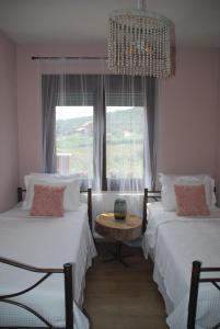 a bedroom with two beds and a window at Olive Tree Cottage in Néa Péramos