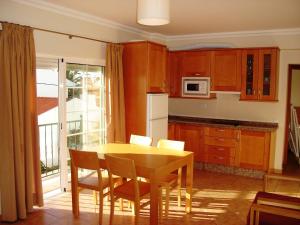 a kitchen with a table and chairs and a kitchen with a window at Alagoa Azul II in Altura