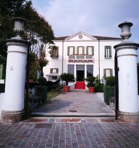 a white house with a gate in front of it at Hotel AB Baretta in Legnaro