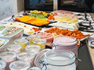 a buffet of different types of food on a table at Topazio Vibe Beach Hotel & Apartments - Adults Friendly in Albufeira