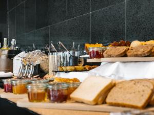 a buffet with bread and other food on a table at Topazio Vibe Beach Hotel & Apartments - Adults Friendly in Albufeira