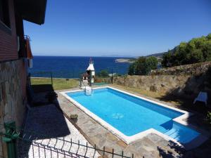 a swimming pool with a view of the ocean at Villa La Ballena de Sonabia in Oriñón