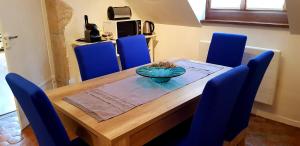 a dining room table with blue chairs and a bowl on it at Appartement Patarin Dijon in Dijon