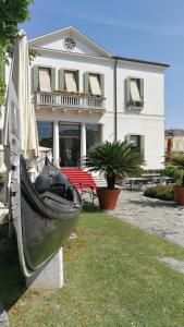 a boat on display in front of a house at Hotel AB Baretta in Legnaro