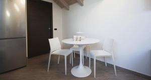 a kitchen with a table and chairs and a refrigerator at La Corte del Gallo in Gallarate