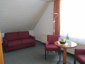 a room with a couch and two chairs and a table at Vitalhotel Weisse Elster in Bad Elster