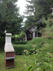 a house with a brick chimney in a yard at Finnhütte Canow in Canow