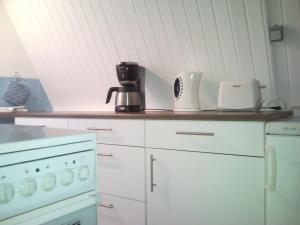 una cocina con encimera con electrodomésticos blancos. en Finnhütte Canow, en Canow