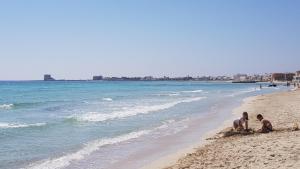 Due uomini che giocano sulla sabbia sulla spiaggia di Torre Lapillo Centro GMA Tourism a Torre Lapillo