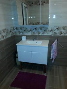 une salle de bains avec un lavabo blanc et un miroir dans l'établissement Apartma Center, à Bovec