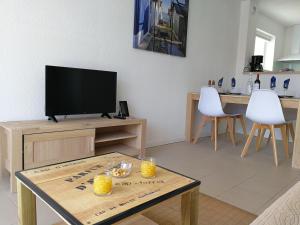 a living room with a tv and a table at Appt. Bella Vita - Andernos les Bains, au cœur du Bassin d'Arcachon in Andernos-les-Bains