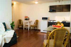 een keuken en een woonkamer met een tafel en stoelen bij Suite 1-B El Rincón Garden House, Welcome To San Angel in Mexico-Stad