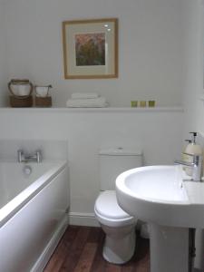 a white bathroom with a toilet and a sink at Warwick Market Place Apartment in Warwick