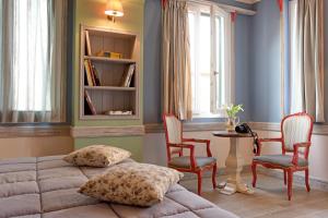 a room with a bed, table, chairs and a window at Puppet Guesthouse in Corfu Town
