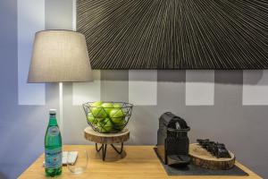 un tavolo con una lampada, un cesto di frutta e una bottiglia di Erïk Langer House a Padova