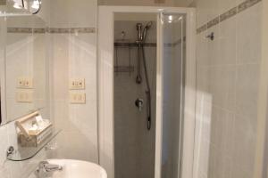a white bathroom with a shower and a sink at Hotel Argentina in Santa Margherita Ligure +37 photos