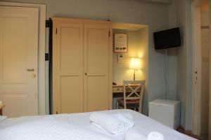 a bedroom with a bed with white sheets and a desk at Hotel Argentina in Santa Margherita Ligure