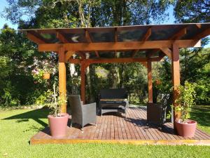 a wooden gazebo with a table and chairs under it at Residencial Pousada do Serrano in Gramado