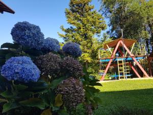 a garden with a playground in the background at Residencial Pousada do Serrano in Gramado