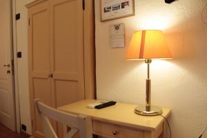 a table with a lamp and a remote control on it at Hotel Argentina in Santa Margherita Ligure