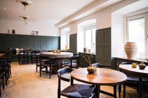 a dining room with tables and chairs and windows at Hotell Breda Blick in Visby