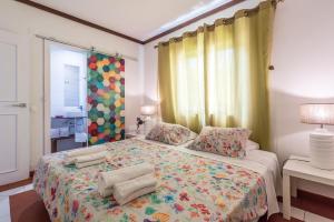 a bedroom with a large bed with a colorful blanket at Villa 39 in Armação de Pêra +22 photos