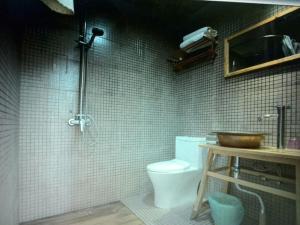 La salle de bains est pourvue de toilettes, d'un lavabo et d'une douche. dans l'établissement Flowers Residence, à Yuanyang