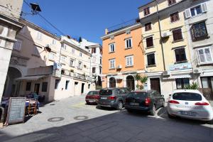 a group of cars parked on a street with buildings at Apartma Mery in Piran