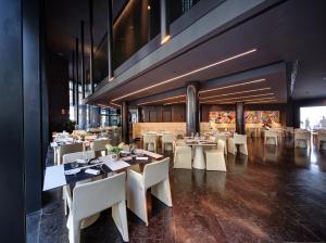 a restaurant with white tables and white chairs at Olivia Balmes Hotel in Barcelona
